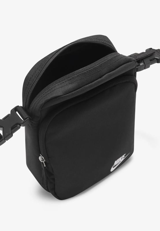 Nike Heritage Cross-Body Men Bag in Black A comfortable and easy-to-adjust strap makes taking the Nike Heritage Waist pack on everyday trips a no-brainer. - -. The main compartment provides secure storage for your phone, snacks or wallet, while the smaller accessories pocket on the back helps keeps things like your keys or travel info safe and close at hand. - -.  The buckle snaps together in the middle of the strap for a comfortable, easy-to-adjust fit. - -. The bag can be worn at your waist, across your body or over your shoulder. - -. Dual zip on the front pocket provides easy access to larger items. - -. Dual zip on the back keeps smaller items stored securely.