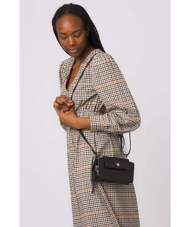 The 'Little Wonder' cross body clutch bag from Conkca London is handcrafted from multi-toned leather for a beautiful finish. A magnetic press-stud secured cover opens to reveal a compartment ideal for a smartphone. A zip-over top opens to reveal a second compartment that is perfect for your essential items and has three handy card slots. Lined with natural and untreated 100% cotton. It comes with an adjustable leather strap with a maximum drop length of 68cm, which is removable, converting the bag into a clutch bag. Adorned with the inimitable Conkca squirrel charm and Conkca logos.