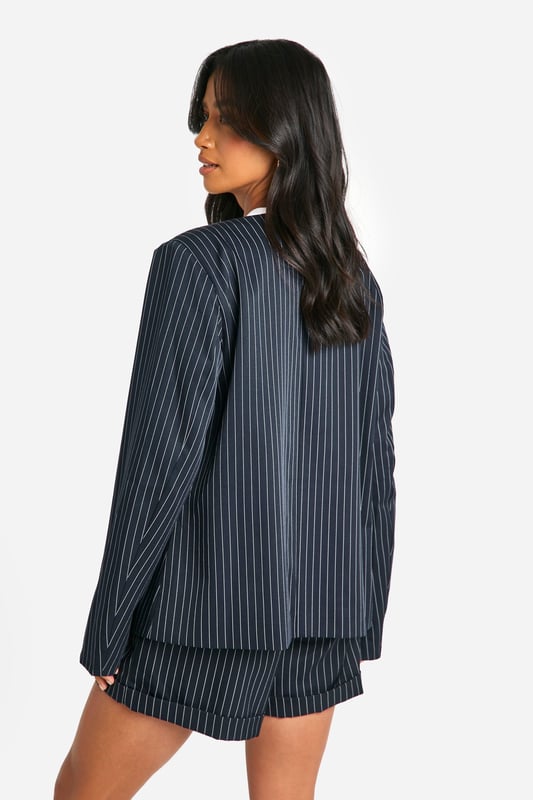 Petite Collarless Pinstripe Tailored Blazer Collarless design for a modern twist on classic tailoring
Pinstripe pattern adds a sophisticated touch
Tailored fit flatters the petite frame
Functional chest pocket for added utility
Versatile piece suitable for both work and casual settings
This petite collarless pinstripe blazer from Boohoo is a versatile addition to any wardrobe. The tailored fit is designed to flatter smaller frames, while the collarless neckline offers a contemporary twist on traditional suiting. Style it as seen on the model with matching shorts for a coordinated look that's perfect for daytime events. For a more casual vibe, pair it with your favourite jeans and trainers. The blazer's adaptability makes it ideal for various occasions, from family gatherings to casual office days. Layer it over a crisp white tee or a silky camisole to switch up your look. The pinstripe pattern adds a touch of sophistication, making this blazer a go-to piece for those wanting to make a stylish statement without compromising on comfort.