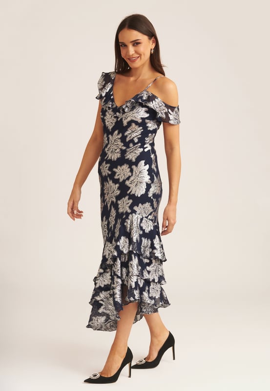 Saluda a este vestido midi con volantes florales imprescindible que es perfecto para cada ocasión. Si tienes una invitación para la boda de tu muñeca favorita, este vestido midi cumple todos los requisitos del código de vestimenta. Con un gran estampado floral y detalle de volante en el escote, ¿cómo podrías decir que no? Combina este vestido midi con tus tacones y tus accesorios favoritos para lograr un look que no pasará desapercibido.