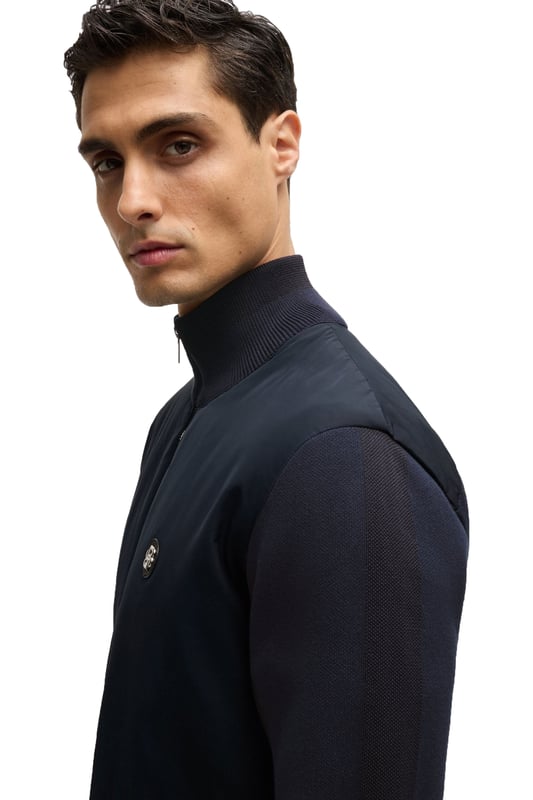 Boss C-Darmando Mixed-material Zip-up Jacket Dark Blue
 
A signature zip-up jacket, cut to a straight fit and crafted in mixed materials for ultimate style and performance. Finished with the all new double-monogram badge at the chest.

Regular fit
Ribbed cuffs
Standard length
Quality: 100% Cotton, Sleeve: 71% Cotton, 29% Polyester, Front panel: 100% Polyester, Front lining: 100% Polyester, Ribbing: 79% Cotton, 21% Polyester, Wadding: 100% Polyester (80% recycled)