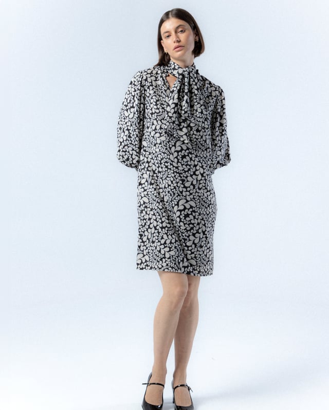 El vestido corto Paula en blanco y negro es sinónimo de elegancia, con este vestido de manga abullonada elevarás tu estilo invernal. Además, su pañuelo a juego te permitirá crear distintos looks con este vestido blanco y negro.
 
 
 
 Vestido corto con cuello pico.
 
 Manga larga acabada con puño con cremallera.
 
 Cierre lateral con cremallera oculta en costura.
 
 Con pañuelo confeccionado en mismo tejido y cara interna con tejido color negro.
 
 Tejido estampado blanco y negro con detalles de foil dorado.