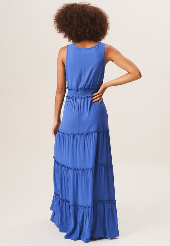 Stay stylish and comfortable in our  Shirred Waist Tiered Midi Dress. This versatile dress features a flattering shirred waist and a tiered design for a fashionable look. Perfect for any occasion, it will effortlessly elevate your wardrobe.