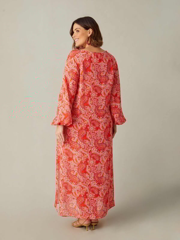 Printed all over with a pretty red paisley print, this dress is cut from a soft woven fabric that moves beautifully. It has a V-neckline with fixed tie detailing, as well as full-length raglan sleeves with elasticated cuffs. Its maxi length makes it the perfect throw-on piece, ideal for any holiday or summer look.