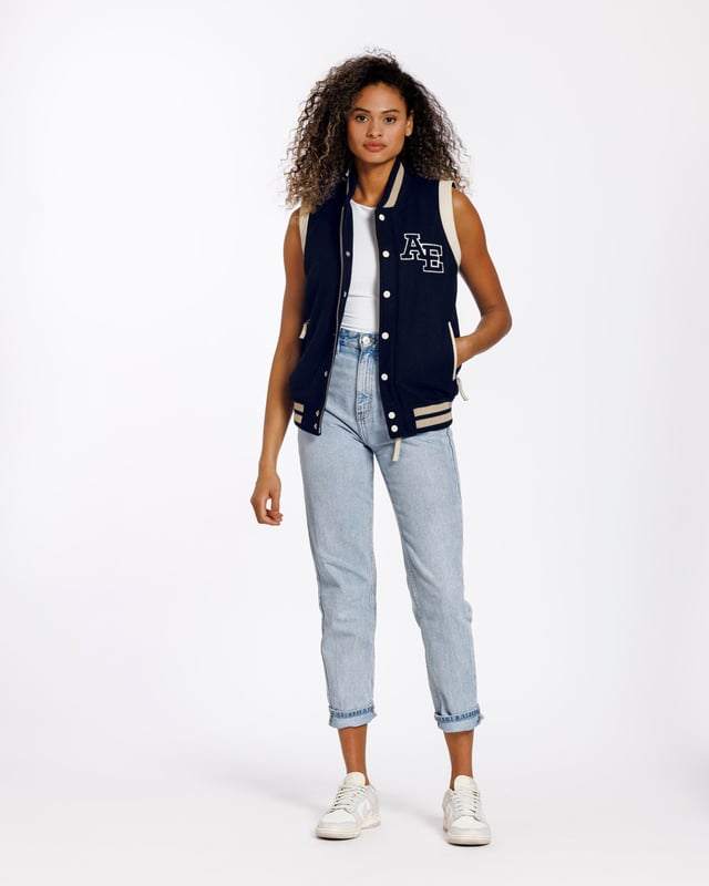 Een varsity gilet van hoge kwaliteit. Een moderne klassieker die altijd in stijl blijft. De jas is gemaakt van schapenwol. Aan beide zijden zitten ritszakken. De ritssluiting aan de voorkant van het jack kan worden gesloten met drukknopen.