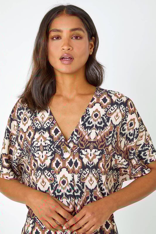 Button Detail Aztec Print Top from Roman. Step into the Summer with neutral prints and relaxed silhouettes. This overshirt has a bold statement button at the front, a feminine v-neckline and short batwing sleeves. It’s designed from a loose woven material for a comfortable and breezy everyday fit. Pair this ikat printed tee with a pair of cropped trousers and wedges for a stylish casual Spring Summer look.