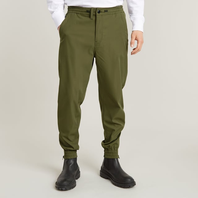 Zip fly, drawcord added. Inset pockets, single back pocket. Stretchable cuffs, relaxed width. Zipper at the lower leg. Pleats inner knee. Zip & button closure. Mid waist. Woven trainer RCT is designed in a loose fit with a relaxed cuff. Inset pockets are combined with a single pocket at the back. The zippers at the ankle add detail. 65% Polyester (Recycled), 35% Elastomultiester. Comfortable stretch. Tapered