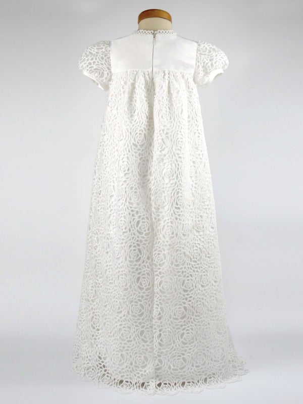 We have reintroduced one of our popular gowns - Ruby. 
  
A stunning Christening robe made with Guipure Lace. A full length dress with a satin bodice, lace sleeves and a beautiful front detail of an organza flower on stunning ribbon tails.  Your child will look very special on the day! 
  
We line our dresses and robes in 100% lightweight Cotton lawn fabric which is cool and better against babies body, especially if they have sensitive skin 
  
The gown arrives to you on a padded Satin hanger and protected by one of our Heritage keepsake garment bags. 
  
Outer - 100% Polyester Mock Silk - Ivory 
Lining - 100% Cotton 
Dry Clean or Hand Wash