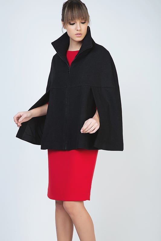 Winter cape in black woven fabric. Fastens in the front with a decorative black plastic zip. Upright colour. Openings for the arms under the bust. Loose fit. Fully lined in black woven fabric. Our model has height 178 cm and wearing size 36. Measurements for size 38 (in cm):Bust-66; Body length-68; Waist-86; Hemline-96. Garment is loose fitted.