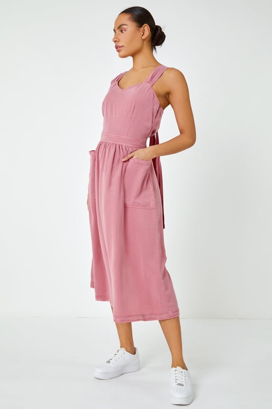 Dyed Strappy Pocket Dress from Roman. It's time to refresh your denim collection by adding this statement detail fit and flare midi dress to your summer wardrobe! This classic feminine piece features a sweetheart halter-neck into back tie detail and front pockets. This timeless one-piece looks great with trainers for an effortless daytime look, alternatively paired with wedges and a sun hat for those stylish city holiday summer breaks abroad.