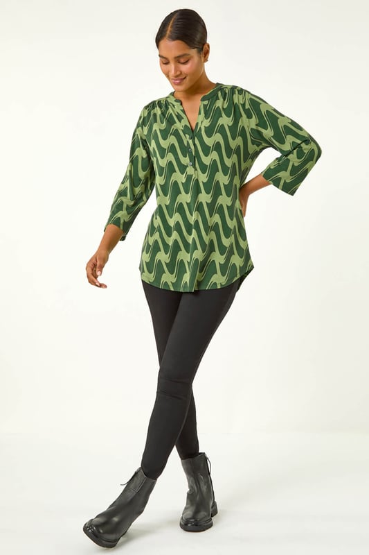 Geometric Print Stretch Blouse from Roman. Elevate your wardrobe this season with our stunning abstract blouse. The bold print and woven silhouette make it versatile for any occasion. The notch neckline, adjustable 3/4 length sleeves and front button details adds a touch of sophistication. Pair it with black jeans and boots for a daytime look or add tailored trousers perfect for those desk-to-dinner days