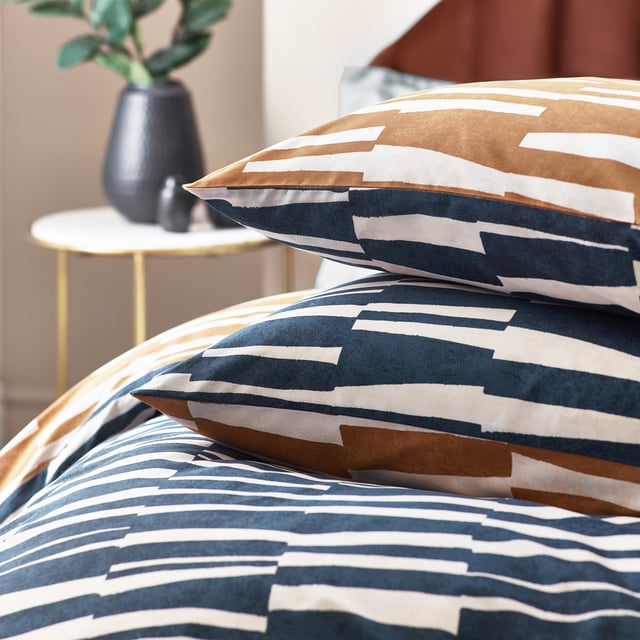 Go to sleep in style with the Piper duvet cover set, inspired by modern, minimalist and abstract art. Create an impact with this modern design, adorned with striking irregular stripes in a tone reminiscence of dusk skies. The reverse features a coordinating print in warming bronze, to offer an alternative design when you need a midweek refresh. A thoroughly modern classic, with a forward-thinking design which will add sophisticated style to your interior. This product is certified by OEKO-TEX® showing it has been sustainably made.