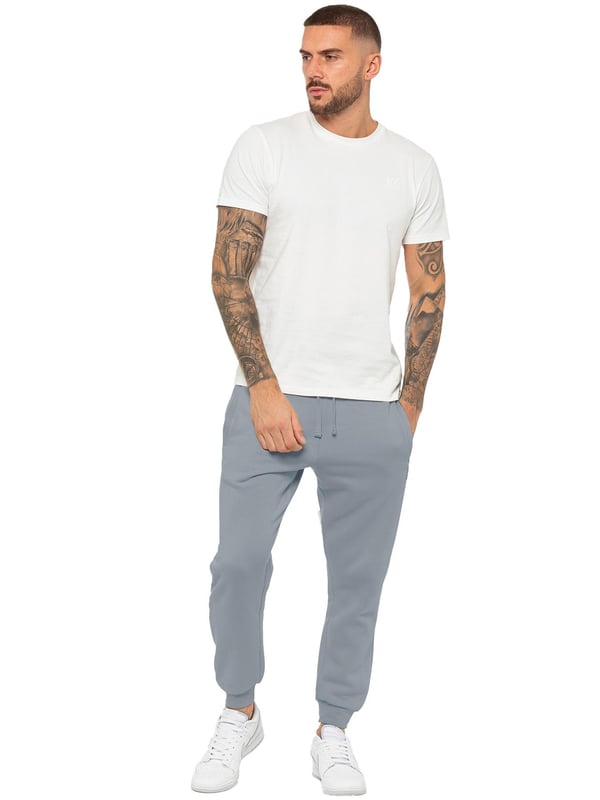 Experience ultimate comfort in our Enzo Mens Regular Fit Joggers. Made with a soft brushed back inner fleece lining, these joggers are perfect for casual wear. The cuffed leg design and elasticated waist with drawstrings provide the perfect fit. With 2 side slash pockets, you can easily carry your essentials.