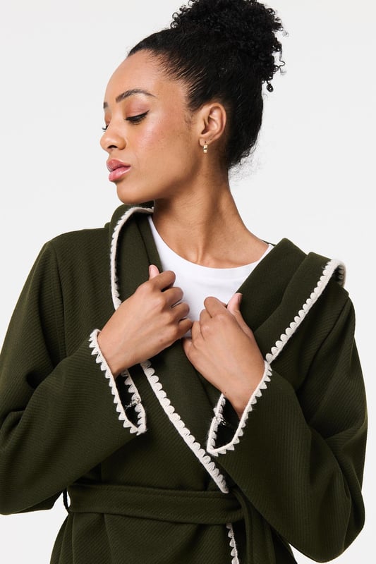Throw on an extra layer in style with this tie up coat. It's finished with a decorative blanket stitch and front pockets, as well as an adjustable waist tie. The longline thigh length hem will look great layered over trousers, jeans or a skirt, so you can wear it with practically any outfit.