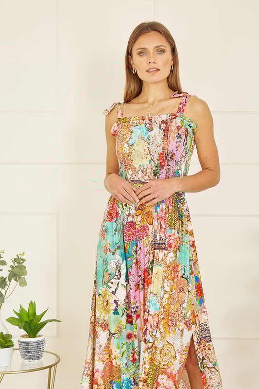 A truly show stopping all over print designed in house for Yumi, inspired by Indian fabrics, with a patchwork feel, This maxi dress will look right at home in the sunshine, with tie straps and a ruched bodice adding a comfortable feel. The maxi length had a flirty side split in the hemline, style with simple sandals and a beach bag.