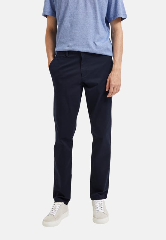 Tauchen Sie ein mit der Herren-Chinohose von Selected Homme. Mit ihrer schlanken Passform und dem schlanken Schnitt an den Oberschenkeln verleiht sie jedem Outfit eine moderne Eleganz. Die Paspeltaschen mit Knopf am Gesäß verleihen der Hose einen Hauch von Raffinesse und Funktionalität. Genießen Sie den ganztägigen Tragekomfort dank der hochwertigen Materialien und der sorgfältigen Verarbeitung. Die seitlichen Eingriffstaschen bieten praktische Aufbewahrungsmöglichkeiten für kleine Gegenstände. Der Reißverschluss und der Knopfverschluss sorgen für einen sicheren Sitz und ein einfaches An- und Ausziehen. Diese Chinohose ist perfekt für Männer, die einen anspruchsvollen Look mit einem Hauch von Lässigkeit suchen. Die Knöchellänge verleiht dem Style einen modernen Touch und ermöglicht es Ihnen, Ihre Lieblingsschuhe zu präsentieren. Die Gürtelschlaufen bieten die Möglichkeit, Ihren persönlichen Stil mit einem Gürtel Ihrer Wahl zu unterstreichen. Von lässigen Wochenendausflügen bis hin zu formellen Anlässen - diese Hose ist vielseitig einsetzbar und passt zu fast jedem Anlass. Erleben Sie den zeitlosen Stil und die Qualität von Selected Homme, die Ihren Look auf ein neues Level heben werden. Gönnen Sie sich den Luxus von Komfort und Stil - mit dieser Chinohose sind Sie immer perfekt gekleidet.