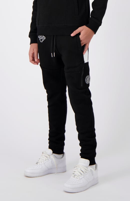 51% polyester | 49% katoen Elastische tailleband met trekkoord Voorzakken met rits Geborduurd Convoy-logo op rechterbeen Zijzak met rits en merkpatch Sportieve strepen aan de zijkanten Kan gecombineerd worden met JR. ANORAK GESTREEPTE HOODIE 