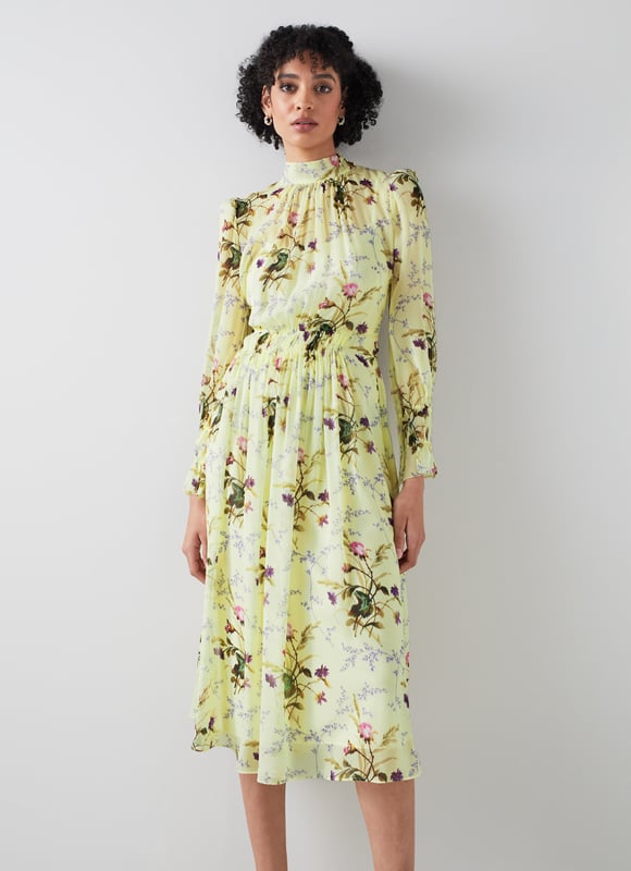 LK Bennett Eloise Dresses, Multi The Eloise dress in the Royal Ascot x LKB collection is crafted from flan yellow silk georgette with a reimagined French 18th century meadow scene in purple, pink and green. It has a slip layer, a round neck with pleat and tie detail, long sleeves with double elasticated cuffs, a gathered waist and a floaty midi skirt.
