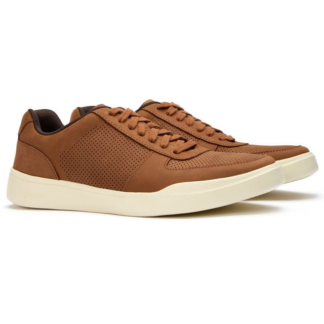 Zapatillas deportivas modernas perforadas Cole Haan para hombre en color tostado, fabricadas con nobuk y suela de goma. Incluyen: diseño de empeine perforado, marca Cole Haan, cuello del talón ligero y acolchado.