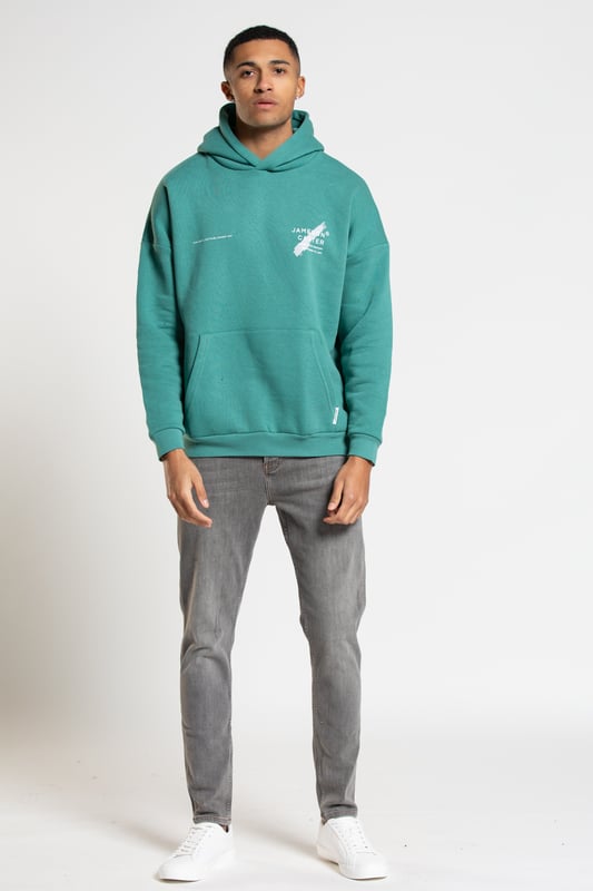 This 'Est' oversized hoodie from Jameson Carter is an everyday essential. Features dropped shoulder, hood, kangaroo pocket, ribbed elasticated cuffs and waistband and Jameson Carter chest and back branding details. This hoody is made from cotton blend fabric and the inside is lined with premium soft fleece to ensure comfort.