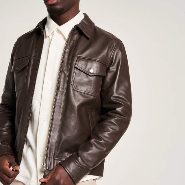 Introducing the Barneys Originals Brown Leather Harrington jacket - a timeless piece crafted for the modern adventurer. With its rich brown hue and classic Harrington silhouette, this jacket exudes rugged sophistication. Perfect for any occasion, whether you're exploring the city streets or unwinding in the countryside, it's the epitome of versatile style and enduring quality.
