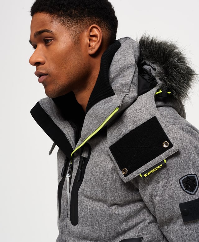 Superdry men’s Deluxe Nordic snow puffer jacket. This padded weather tolerant jacket with an inner ribbed collar, detachable hood with a removable faux fur trim and a taped seam zip fastening is perfect for hitting the slopes in. The Deluxe Nordic snow puffer jacket features five outer pockets – one with a detachable goggle cloth, hook and loop fastened cuffs with thumbholes and zip fastened armpit ventilation. Inside, the jacket has a removable snow skirt and a single internal pocket with earphone routing. The jacket is finished with Superdry branding on the zips, placket, shoulder and arms. Water resistance  10,000mm 
Breathability  10,000g
Snow seals and coated zipsModel wears: Medium Model height: 6’ 1” (185cm) Model chest size: 38" (96cm)