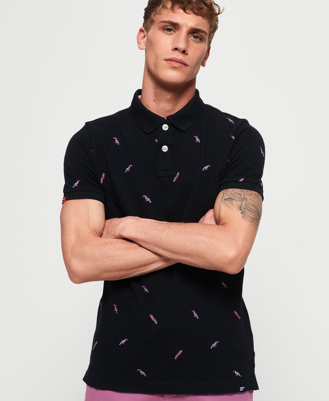 Superdry men's Bermuda polo shirt. This classic style polo shirt features short sleeves, two button fastening and an all over embroidered pattern. Finished with a Superdry logo tab on the hem and on one sleeve. Will look great with a pair of jeans or shorts and trainers this season.