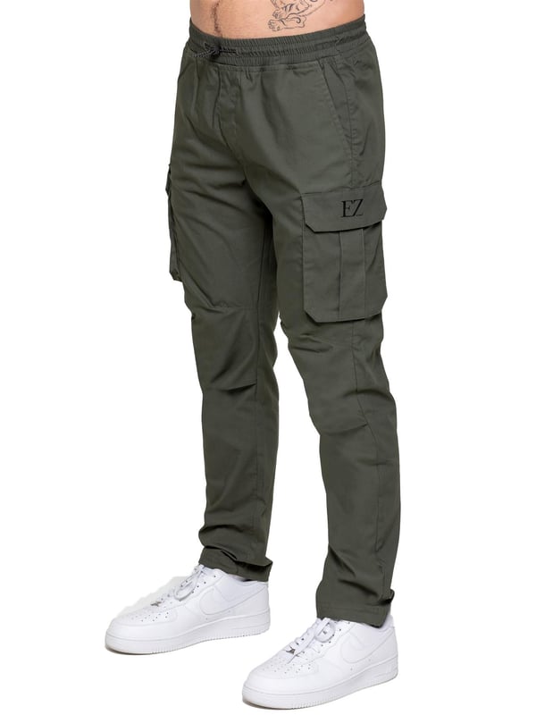 Upgrade your everyday style with the Enzo Men's Cargo Pants. Crafted from premium stretch fabric, these lightweight trousers offer a tapered leg fit for a sleek, modern look. Featuring an elasticated waistband with an adjustable toggle, they provide a customizable fit, while the adjustable toggle ankles let you tailor the look and feel. With two side slash pockets, two cargo pockets with secure Velcro fastening, and a single back welt pocket, you’ll have ample storage for essentials. Finished with an Enzo print on the cargo pocket. (649)