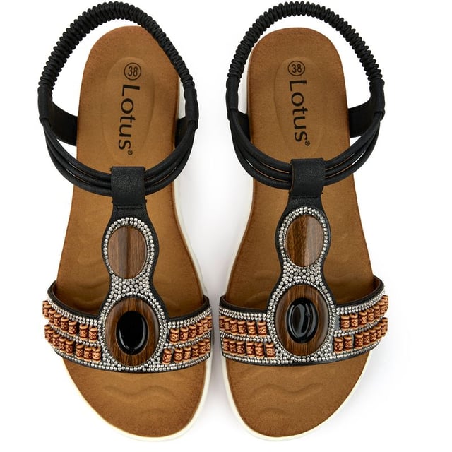 Descubra las sandalias Lotus Bertolini, donde el lujo se une a la comodidad. Estos elegantes zapatos de verano cuentan con una elegante parte superior con bonitos detalles decorativos para mayor glamour, una correa trasera elástica y una suela de goma duradera. Diseñados tanto para la diosa del sol vanguardista como para el creador de tendencias informal, ofrecen un ajuste cómodo con un aspecto fabuloso.