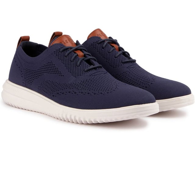 The Cole Haan Grand+ Stitchlite trainers look sharp and will give you a spring in your step thanks to their lightweight Stitchlite uppers and responsive Grand 360 sole technology. These sleek navy shoes showcase classic brogue detailing and hug your feet with their sock-like fit and plush comfort insole. Finished with Cole Haan branding, the contemporary Stitchlite sneaker keeps it simple yet stylish. So lace up, go the distance and feel the freedom of near-weightless comfort in the Cole Haan Stitchlite.