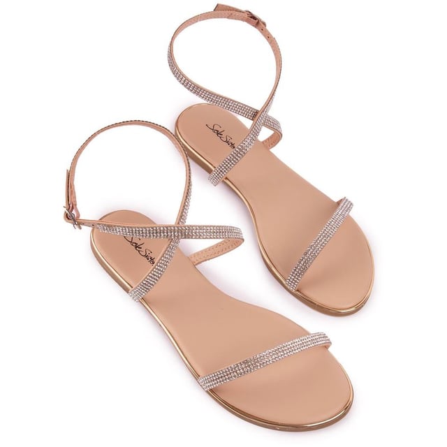 Las sandalias Lane de SOLE son un par de zapatos planos metálicos color nude y bronce con un toque súper chic y ultrafemenino. Con correas delicadamente cubiertas de diamantes y una correa ajustable en el tobillo, este modelo glamuroso es perfecto para un día soleado y una cálida noche de verano.