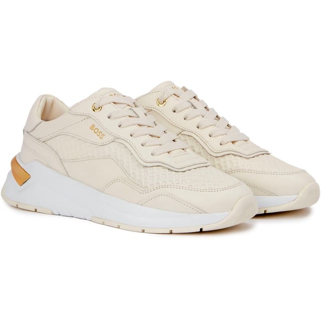 Presentamos Boss Skylar Runn, la fusión perfecta de estilo, moda y funcionalidad. Estas suaves zapatillas blancas están confeccionadas con una lujosa parte superior de cuero y una suela de goma para máxima comodidad y durabilidad. Las zapatillas cuentan con un impresionante detalle dorado en el talón, que añade un toque de glamour a tu rutina de carrera. Mejora tu juego con Boss Skylar Runn y disfruta de tu día con elegancia y sencillez.