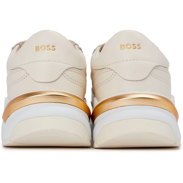 Presentamos Boss Skylar Runn, la fusión perfecta de estilo, moda y funcionalidad. Estas suaves zapatillas blancas están confeccionadas con una lujosa parte superior de cuero y una suela de goma para máxima comodidad y durabilidad. Las zapatillas cuentan con un impresionante detalle dorado en el talón, que añade un toque de glamour a tu rutina de carrera. Mejora tu juego con Boss Skylar Runn y disfruta de tu día con elegancia y sencillez.