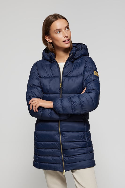 Der Mantel Corinne ist Teil unserer Ultralight-Damenkollektion. Dieser gesteppte Mantel mit abnehmbarer Kapuze ist aus recyceltem Polyester hergestellt. Wasserabweisend und mit warmer, ultraleichter Füllung, die zudem umweltfreundlich ist. Er verfügt über einen goldfarbenen Metallreißverschluss auf der Vorderseite mit personalisiertem Polo Club Zipper, zwei Seitentaschen und eine Innentasche mit Reißverschluss. Manschetten und Kapuze mit elastischen Bündchen mit Markenlogo für mehr Anpassungsfähigkeit. Abnehmbare Kapuze. Mit hochauflösendem Polo Club Textiletikett.