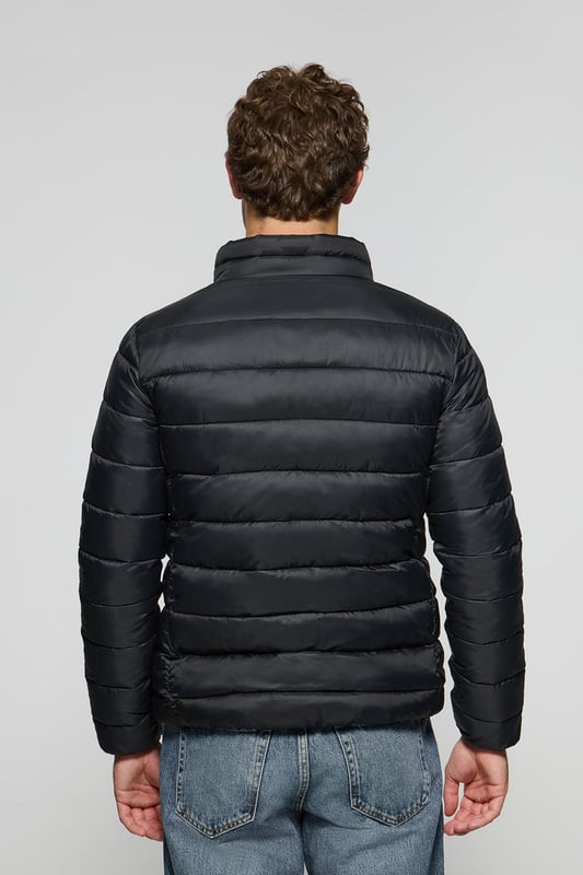 Unsere Ultralight-Herrenjacke Chase zeichnet sich durch ein modernes und funktionelles Design aus. Die leichte Steppung wärmt, ohne den Komfort zu beeinträchtigen. Sie ist ohne Kapuze und mit Reißverschluss ausgestattet und verfügt über zwei Seitentaschen und eine Innentasche mit Reißverschluss für zusätzliche Funktionalität. Das Kleidungsstück ist wasserabweisend, jedoch nicht völlig wasserdicht, was es zu einer perfekten Wahl für eine Vielzahl von Wetterbedingungen macht. Unser neuer gummierter, farblich angepasster Rigby Go Aufnäher auf der Brust, die schrägen Einsätze und das Futter in Kontrastfarbe machen dieses Kleidungsstück zu einem modernen Klassiker.