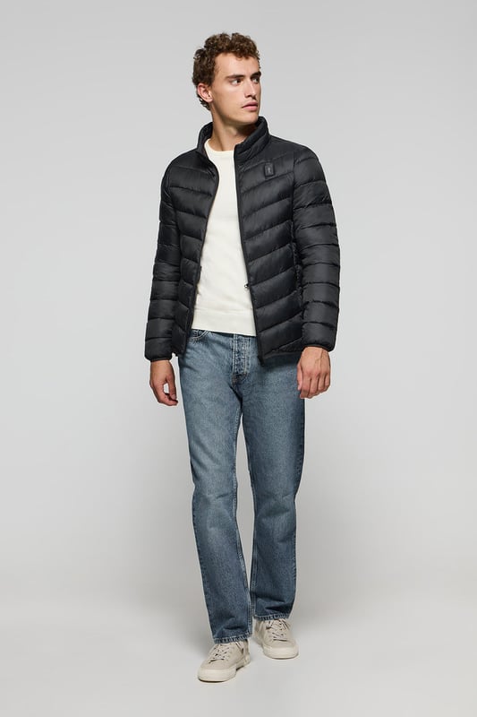 Unsere Ultralight-Herrenjacke Chase zeichnet sich durch ein modernes und funktionelles Design aus. Die leichte Steppung wärmt, ohne den Komfort zu beeinträchtigen. Sie ist ohne Kapuze und mit Reißverschluss ausgestattet und verfügt über zwei Seitentaschen und eine Innentasche mit Reißverschluss für zusätzliche Funktionalität. Das Kleidungsstück ist wasserabweisend, jedoch nicht völlig wasserdicht, was es zu einer perfekten Wahl für eine Vielzahl von Wetterbedingungen macht. Unser neuer gummierter, farblich angepasster Rigby Go Aufnäher auf der Brust, die schrägen Einsätze und das Futter in Kontrastfarbe machen dieses Kleidungsstück zu einem modernen Klassiker.