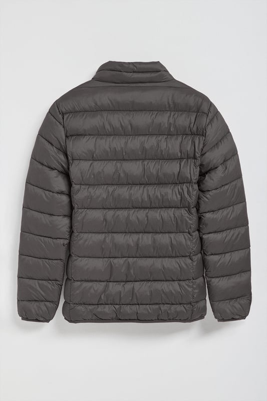 Unsere Ultralight-Herrenjacke Chase zeichnet sich durch ein modernes und funktionelles Design aus. Die leichte Steppung wärmt, ohne den Komfort zu beeinträchtigen. Sie ist ohne Kapuze und mit Reißverschluss ausgestattet und verfügt über zwei Seitentaschen und eine Innentasche mit Reißverschluss für zusätzliche Funktionalität. Das Kleidungsstück ist wasserabweisend, jedoch nicht völlig wasserdicht, was es zu einer perfekten Wahl für eine Vielzahl von Wetterbedingungen macht. Unser neuer gummierter, farblich angepasster Rigby Go Aufnäher auf der Brust, die schrägen Einsätze und das Futter in Kontrastfarbe machen dieses Kleidungsstück zu einem modernen Klassiker.