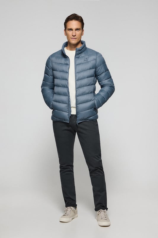 Unsere Ultralight-Herrenjacke Chase zeichnet sich durch ein modernes und funktionelles Design aus. Die leichte Steppung wärmt, ohne den Komfort zu beeinträchtigen. Sie ist ohne Kapuze und mit Reißverschluss ausgestattet und verfügt über zwei Seitentaschen und eine Innentasche mit Reißverschluss für zusätzliche Funktionalität. Das Kleidungsstück ist wasserabweisend, jedoch nicht völlig wasserdicht, was es zu einer perfekten Wahl für eine Vielzahl von Wetterbedingungen macht. Unser neuer gummierter, farblich angepasster Rigby Go Aufnäher auf der Brust, die schrägen Einsätze und das Futter in Kontrastfarbe machen dieses Kleidungsstück zu einem modernen Klassiker.