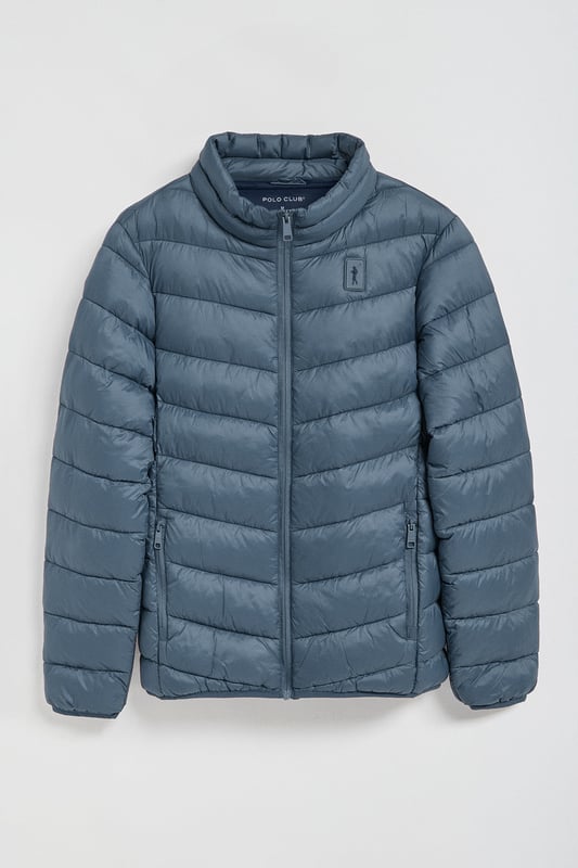 Unsere Ultralight-Herrenjacke Chase zeichnet sich durch ein modernes und funktionelles Design aus. Die leichte Steppung wärmt, ohne den Komfort zu beeinträchtigen. Sie ist ohne Kapuze und mit Reißverschluss ausgestattet und verfügt über zwei Seitentaschen und eine Innentasche mit Reißverschluss für zusätzliche Funktionalität. Das Kleidungsstück ist wasserabweisend, jedoch nicht völlig wasserdicht, was es zu einer perfekten Wahl für eine Vielzahl von Wetterbedingungen macht. Unser neuer gummierter, farblich angepasster Rigby Go Aufnäher auf der Brust, die schrägen Einsätze und das Futter in Kontrastfarbe machen dieses Kleidungsstück zu einem modernen Klassiker.