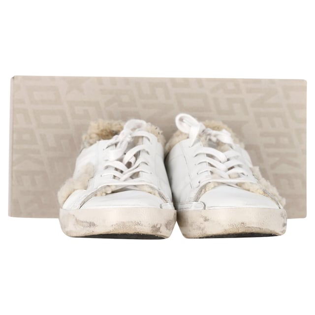 VINTAGE, UVP WIE NEU  
Die Golden Goose Superstar Shearling-gefütterten Distressed Sneakers aus weißem Leder vereinen rustikalen Charme mit Luxus. Gefertigt aus weichem Leder mit Wildleder-Fersenelementen, verfügen diese Sneakers über ein kuscheliges Shearling-Futter für ultimativen Komfort. Die charakteristischen silberglitzernden Sterne verleihen ihrem mühelos lässigen, abgenutzten Design einen Hauch Glamour.

mit Box  

Golden Goose Superstar Shearling-gefütterte Distressed Sneakers aus weißem Leder  
Zustand: Sehr gut  
Abnutzungserscheinungen: Einschließlich Box, kleinere Markierungen, leicht benutzt, aber sehr gut gepflegt. Kleinere Markierung an der Sohle & Faltenbildung, leichte Abschürfungen an der Sohle und den Fersen.  
Verpackung: Box  
Farbe: Weiß | ecru  
Material: Leder und Shearling  
Größe: EU | 42/US12  
Maße: Absatzhöhe: 20; Innensohlenlänge: 310  
SKU: NAPPUGBSH452947W