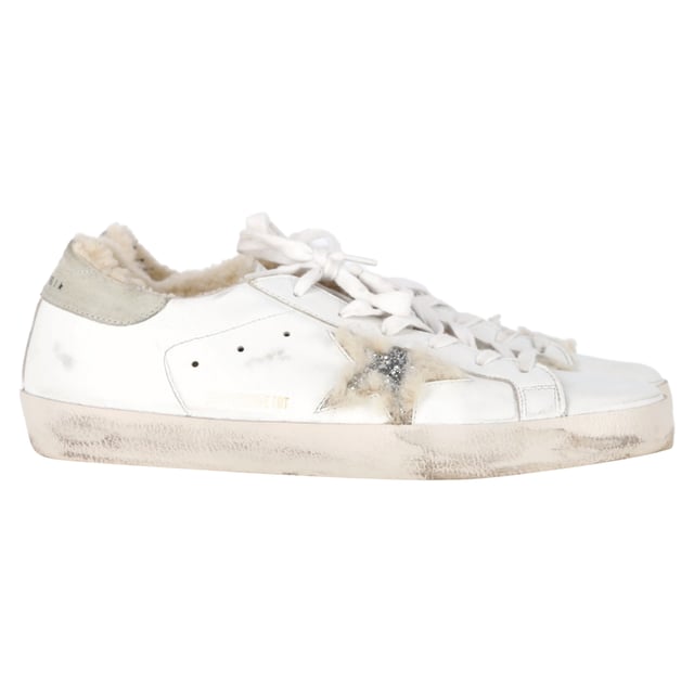 VINTAGE, UVP WIE NEU  
Die Golden Goose Superstar Shearling-gefütterten Distressed Sneakers aus weißem Leder vereinen rustikalen Charme mit Luxus. Gefertigt aus weichem Leder mit Wildleder-Fersenelementen, verfügen diese Sneakers über ein kuscheliges Shearling-Futter für ultimativen Komfort. Die charakteristischen silberglitzernden Sterne verleihen ihrem mühelos lässigen, abgenutzten Design einen Hauch Glamour.

mit Box  

Golden Goose Superstar Shearling-gefütterte Distressed Sneakers aus weißem Leder  
Zustand: Sehr gut  
Abnutzungserscheinungen: Einschließlich Box, kleinere Markierungen, leicht benutzt, aber sehr gut gepflegt. Kleinere Markierung an der Sohle & Faltenbildung, leichte Abschürfungen an der Sohle und den Fersen.  
Verpackung: Box  
Farbe: Weiß | ecru  
Material: Leder und Shearling  
Größe: EU | 42/US12  
Maße: Absatzhöhe: 20; Innensohlenlänge: 310  
SKU: NAPPUGBSH452947W