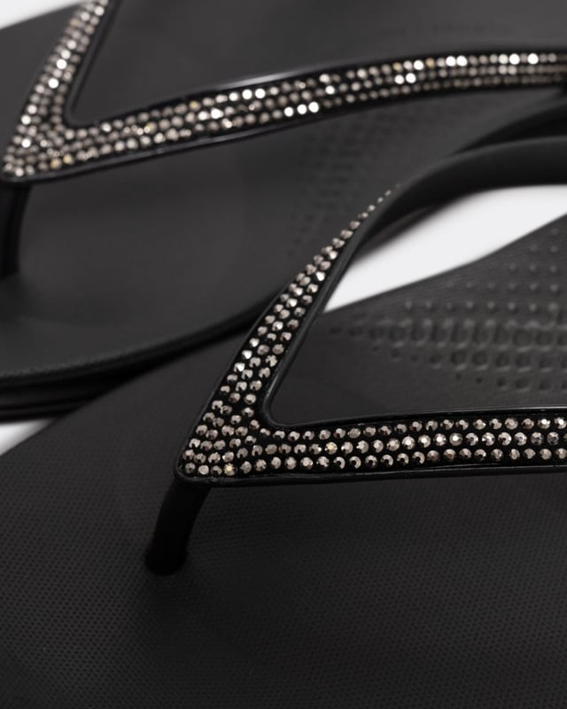 From the top, they look like your typical surfer-girl flip flops. Underneath, they’re engineered with iQushion™ air-foam cushioning, with impact pillows at high pressure areas, for non-stop comfort. These sparkly flip flops are adorned with micro-'crystals', throw a pair in your suitcase and you’ll find yourself wearing them to beach, bar and beyond. Waterproof and slip-resistant.Because of the design of this version, iQushion charms do not fit on these flip-flops.Sizing note: These iQushion flip-flops fit slightly small. If you fit between sizes, we recommend that you go up in size rather than down.
Upper Material:RubberLining Material:UnlinedFastening:Slip-OnOutsole:EVATechnology:iQushion
R08
 
