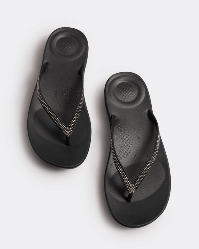 From the top, they look like your typical surfer-girl flip flops. Underneath, they’re engineered with iQushion™ air-foam cushioning, with impact pillows at high pressure areas, for non-stop comfort. These sparkly flip flops are adorned with micro-'crystals', throw a pair in your suitcase and you’ll find yourself wearing them to beach, bar and beyond. Waterproof and slip-resistant.Because of the design of this version, iQushion charms do not fit on these flip-flops.Sizing note: These iQushion flip-flops fit slightly small. If you fit between sizes, we recommend that you go up in size rather than down.
Upper Material:RubberLining Material:UnlinedFastening:Slip-OnOutsole:EVATechnology:iQushion
R08
 