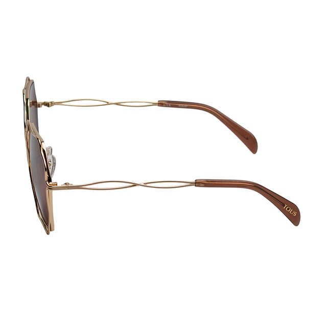 Gafas de sol TOUS con montura de metal.

Forma y diseño:
- Estas gafas Tous tienen una silueta octogonal con bordes ondulados.
- La forma de las lentes les otorga un aspecto elegante y único.

Material de la montura:
- La montura de estas gafas está fabricada en metal.
- El uso de metal proporciona durabilidad y ligereza a la montura.
- Esto hace que las gafas de sol sean resistentes y cómodas de llevar.

Patillas metálicas:
- Las patillas también están hechas de metal, a juego con el material de la montura con acabado en acetato.
- El metal en las patillas agrega solidez y estabilidad a la estructura de las gafas.

Detalles de la marca:
- Grabado de la marca Tous en la patilla.
- Logo de Tous en una de las lentes.
- Estos elementos de diseño ayudan a identificar claramente el modelo como parte de la colección de gafas de sol Tous.

Lentes:
- Los lentes son de alta calidad.
- 100% protección UVB 400.
 Medidas: Alto lente: 60 mm. Ancho lente: 57 mm. Puente: 19 mm. Patillas: 140 mm.
 Composición: Metal
 Cuidados:
Usar un paño de microfibra.
Evitar productos agresivos.
Lavar con agua y jabón neutro.