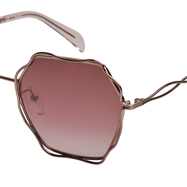 Gafas de sol TOUS con montura de metal.

Forma y diseño:
- Estas gafas Tous tienen una silueta octogonal con bordes ondulados.
- La forma de las lentes les otorga un aspecto elegante y único.

Material de la montura:
- La montura de estas gafas está fabricada en metal.
- El uso de metal proporciona durabilidad y ligereza a la montura.
- Esto hace que las gafas de sol sean resistentes y cómodas de llevar.

Patillas metálicas:
- Las patillas también están hechas de metal, a juego con el material de la montura con acabado en acetato.
- El metal en las patillas agrega solidez y estabilidad a la estructura de las gafas.

Detalles de la marca:
- Grabado de la marca Tous en la patilla.
- Logo de Tous en una de las lentes.
- Estos elementos de diseño ayudan a identificar claramente el modelo como parte de la colección de gafas de sol Tous.

Lentes:
- Los lentes son de alta calidad.
- 100% protección UVB 400.
 Medidas: Alto lente: 60 mm. Ancho lente: 57 mm. Puente: 19 mm. Patillas: 140 mm.
 Composición: Metal
 Cuidados:
Usar un paño de microfibra.
Evitar productos agresivos.
Lavar con agua y jabón neutro.