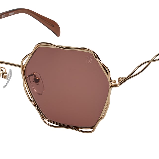 Gafas de sol TOUS con montura de metal.

Forma y diseño:
- Estas gafas Tous tienen una silueta octogonal con bordes ondulados.
- La forma de las lentes les otorga un aspecto elegante y único.

Material de la montura:
- La montura de estas gafas está fabricada en metal.
- El uso de metal proporciona durabilidad y ligereza a la montura.
- Esto hace que las gafas de sol sean resistentes y cómodas de llevar.

Patillas metálicas:
- Las patillas también están hechas de metal, a juego con el material de la montura con acabado en acetato.
- El metal en las patillas agrega solidez y estabilidad a la estructura de las gafas.

Detalles de la marca:
- Grabado de la marca Tous en la patilla.
- Logo de Tous en una de las lentes.
- Estos elementos de diseño ayudan a identificar claramente el modelo como parte de la colección de gafas de sol Tous.

Lentes:
- Los lentes son de alta calidad.
- 100% protección UVB 400.
 Medidas: Alto lente: 60 mm. Ancho lente: 57 mm. Puente: 19 mm. Patillas: 140 mm.
 Composición: Metal
 Cuidados:
Usar un paño de microfibra.
Evitar productos agresivos.
Lavar con agua y jabón neutro.
