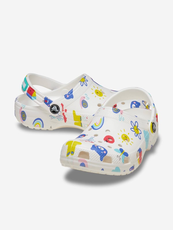Introducing the Kids Classic Doodle Print Clog in White from Crocs, the perfect stylish and comfortable footwear choice for your child for AW2024. Here's why it's a must-have:‚Unique Doodle Design: Features fun  creative prints that pop against the classic white backdrop.‚Supreme Comfort: Crafted with Crocs‚ iconic Croslite‚ foam, offering a cushiony ride all day long.‚Versatile Wear: Ideal for both indoor Cosiness and outdoor adventures.‚Easy to Clean: Just soap and water, and they're ready for the next playful day.Step up your child‚ style game with these trendy clogs! Order now!