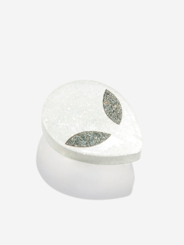 Elevate your Crocs with the Glitter Alien Jibbitz‚ charm! This cosmic accessory features a cute alien silhouette filled with sparkling glitter. Easy to insert and remove, it adds a playful touch to your footwear. Embrace the extra-terrestrial trend and personalise your Crocs with this eye-catching charm today!

NOTE: Sold Separately to Shoe

‚Not a Toy
‚Not Intended For Children Under 3 Years Of Age