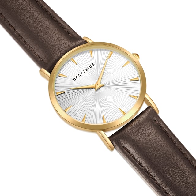 GENERAL INFORMATION:  • Targetgroup: Female  • Wristwatch: No Special Functions  • Display: analogue  • Weight of watch w/o box (gr.) - approx.: 26,0  MOVEMENT:  • Movement: Quartz  • Term of Movement: 2025  • Origin of movement: Japan  BRACELET:  • Material of bracelet/strap: Genuine leather  • Plating of bracelet/strap: None  • Finishing of bracelet/strap: Smooth  • Finishing/Decoration of bracelet/strap: Seam  • Clasp/Closure/Buckle: Buckle  • Color of bracelet/strap: Dark brown  • Length of bracelet/strap (mm) approx.: 190,0  • Width of bracelet/strap (mm) approx.: 18,0  • Style/Design of bracelet/strap: No imprint  • Bracelet/strap adjustable?: No  CASE:  • Shape of case: Round  • Size/Diameter of case in mm . approx.: 33,0  • Height of case in mm: 6,7  • Case material: Metal (Alloy)  • Surface of case: Polished  • Bezel/Topring: Fixed  • Finishing/Decoration of case: None  • Material of case back: Stainless steel  • Lock of case back: No screwed-in crown  • Color of case: Yellowgold  • Coating/Plating (Case): Ion-Plating (IP)  • Type/Form of crystal: Flat  • Material of crystal: Mineral crystal  • Water resistant (ATM): 3  DIAL:  • Size jewelry care cloth: Hour, Minute  • Indices: Line indices  • Material of dial: Brass  • Structure/pattern of dial: sunray  • Color of dial: White  PUSHER, CROWN, HAND:  • Pusher: None  • Corrector: No  • Crown: No screwed-in crown  • Type of hands: Dauphine hands  • Luminescent (hands): No  PACKAGING & SCOPE OF DELIVERY:  • Box: Yes  • Service booklet: Yes  • Manual: Yes