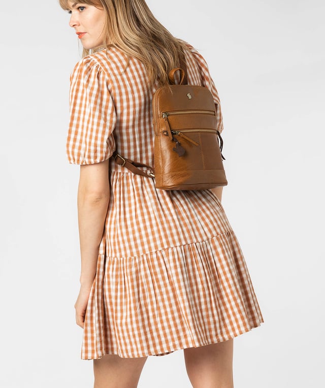 Handcrafted from natural leather for a beautifully textured finish the 'Francisca' backpack from Conkca London features plentiful on-the-go storage. The main zipped compartment comes lined with natural and untreated 100% cotton with two interior pockets, ideal for a smartphone and keys. Dual zips on the front of the backpack provide extra storage solutions. Comes with adjustable and durable fabric shoulder straps finished with the inimitable Conkca squirrel logo and charm.